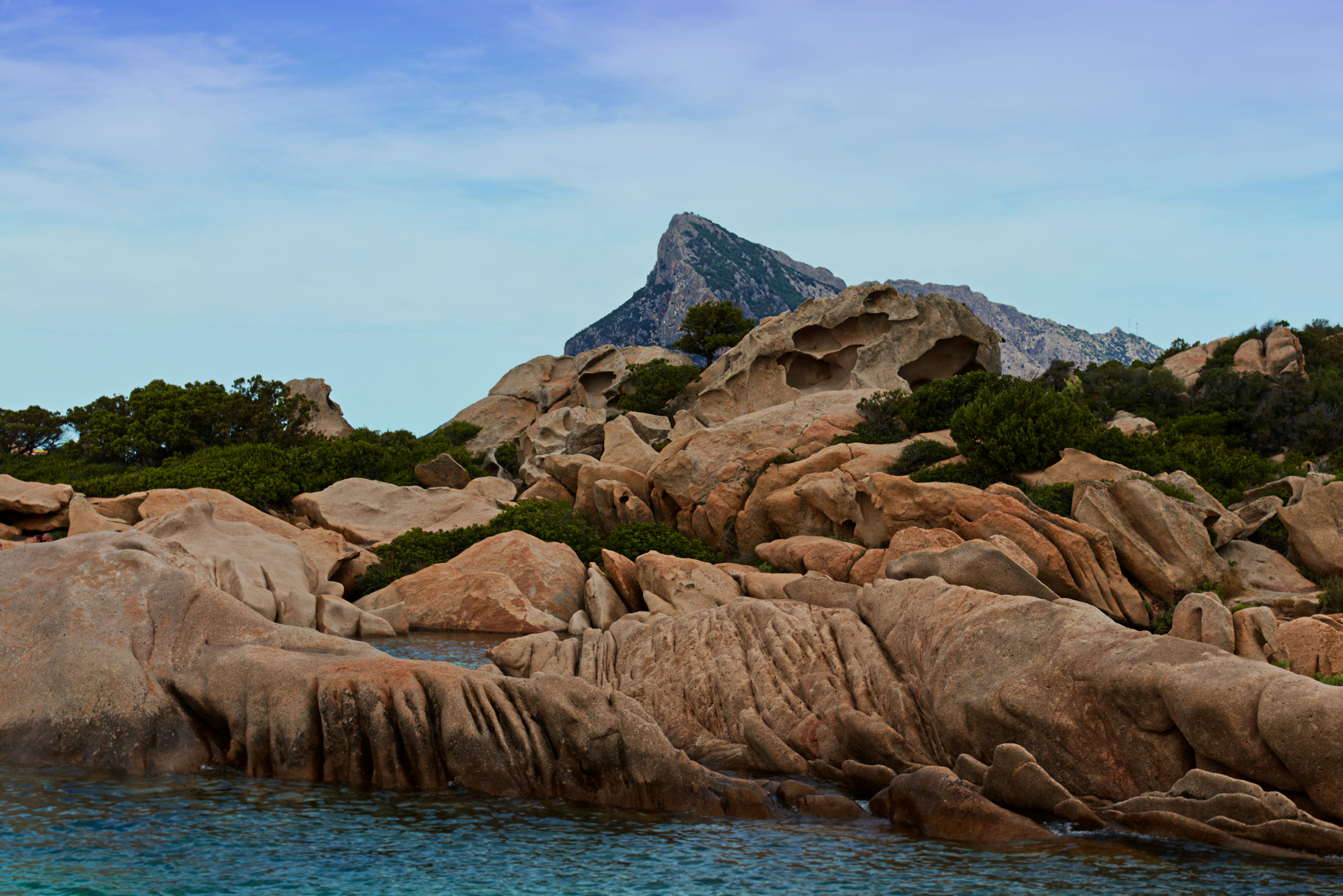 brown rock formation near body of water during daytime